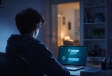 Adolescent utilisant un assistant conversationnel sur ordinateur dans un espace d’étude, avec une présence familiale suggérée en arrière-plan.